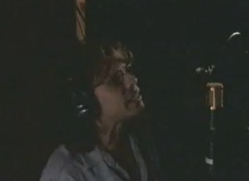 Steven Tyler singing at a studio microphone